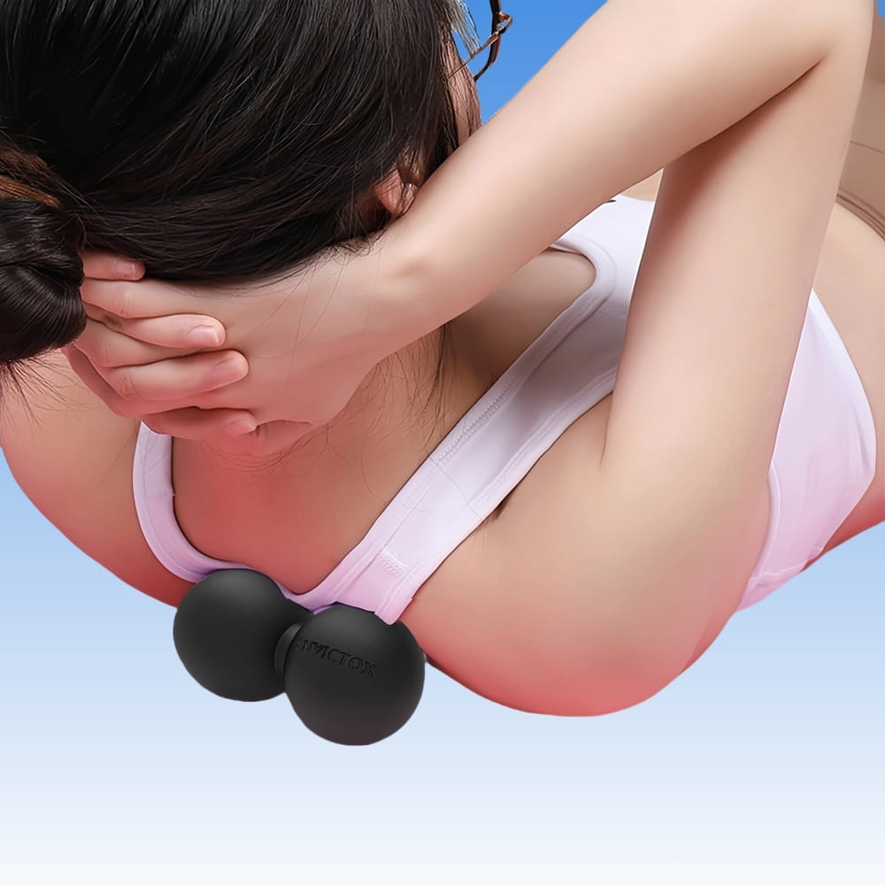 Person using a black massage ball on their back against a blue background