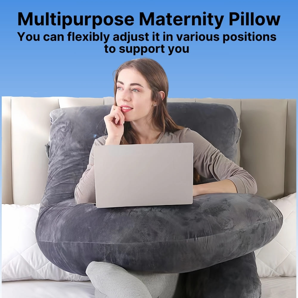 Woman using a multipurpose maternity pillow while sitting on a couch with a laptop.