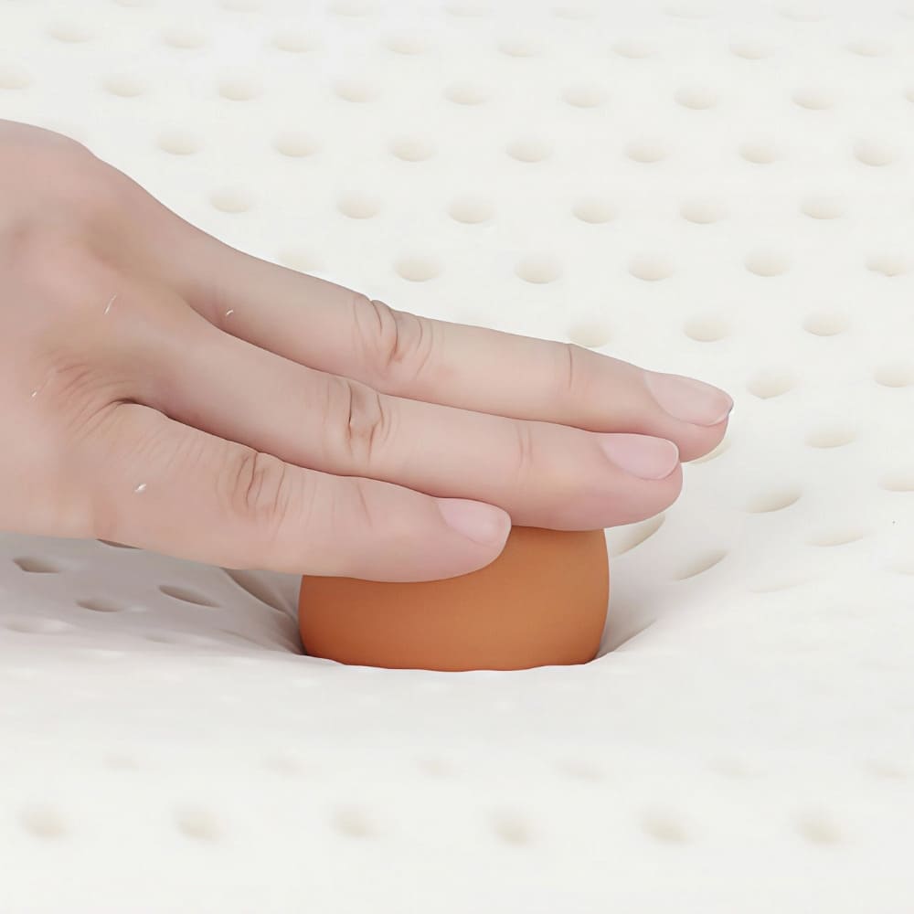 ByeAche bone-shaped latex car headrest pillow on perforated surface