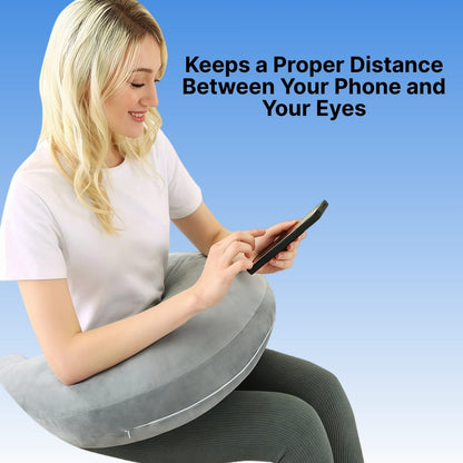 Woman using a phone with a gray cushion under her desk against a blue background
