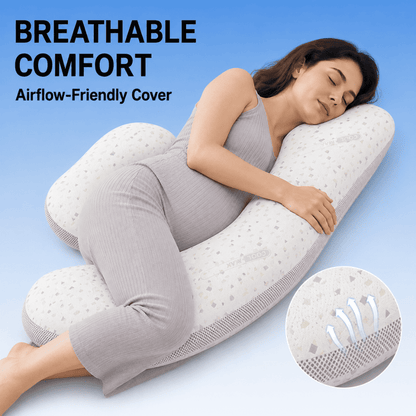 A woman in a light gray ribbed pajama set rests on a white U-shaped maternity pillow with a dotted pattern, set against a blue gradient background with text reading 'BREATHABLE COMFORT Airflow-Friendly Cover' and a circular inset showing airflow details.