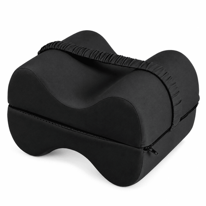A black contoured lumbar support pillow with a zippered storage compartment and a gathered elastic strap, shown on a plain white background.