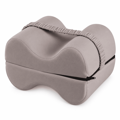 A contoured memory foam pillow in a muted taupe-gray color, featuring a matching fabric neck support strap and a black zipper closure, shown on a solid white background.