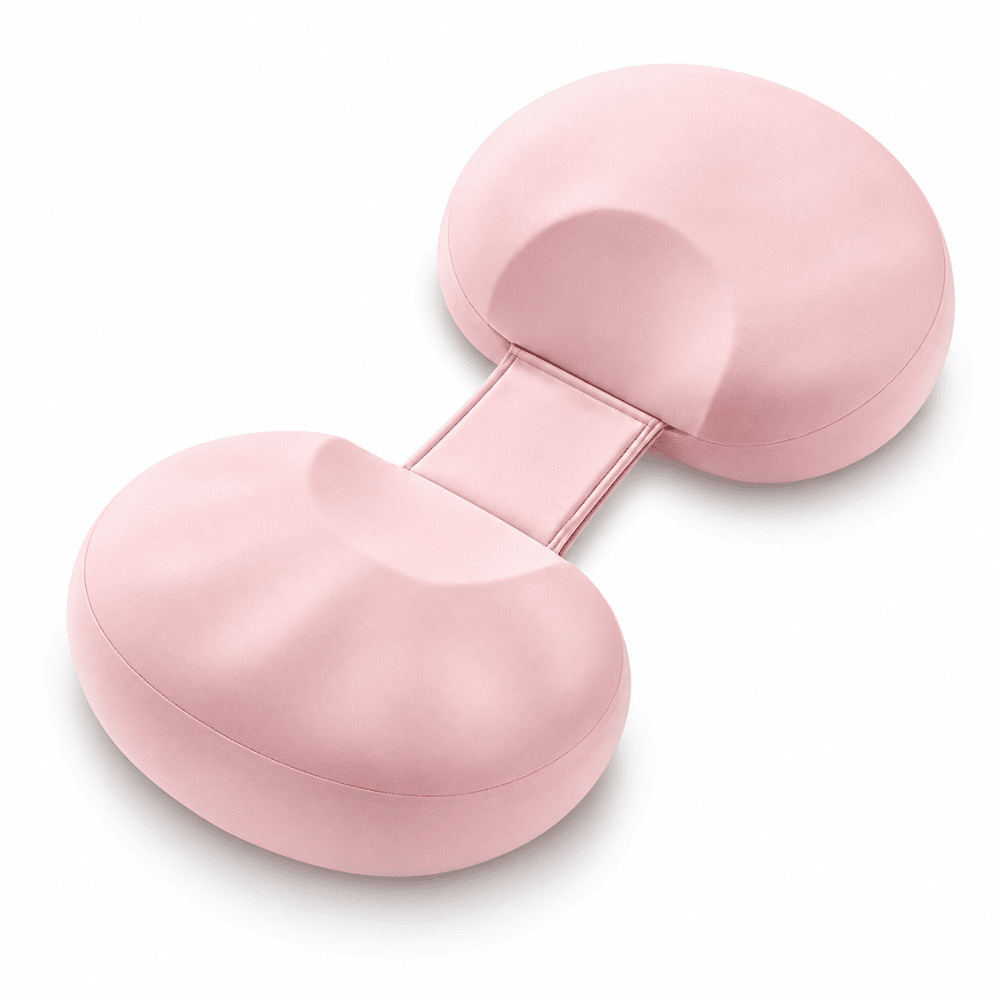 A light pink ergonomic split cushion with two rounded, contoured sections connected by a central strap, shown on a clean white background.