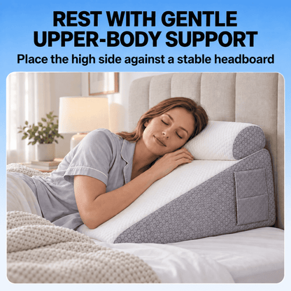 A woman rests on a wedge-shaped bed support pillow in a bedroom setting, with text at the top reading 'REST WITH GENTLE UPPER-BODY SUPPORT' and 'Place the high side against a stable headboard.' The pillow is white with gray patterned side panels.